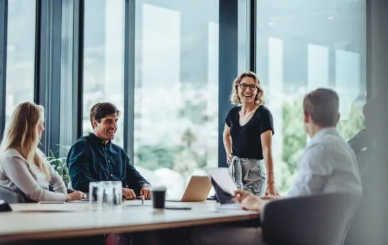 Office colleagues have a casual discussion during a meeting in a boardroom.