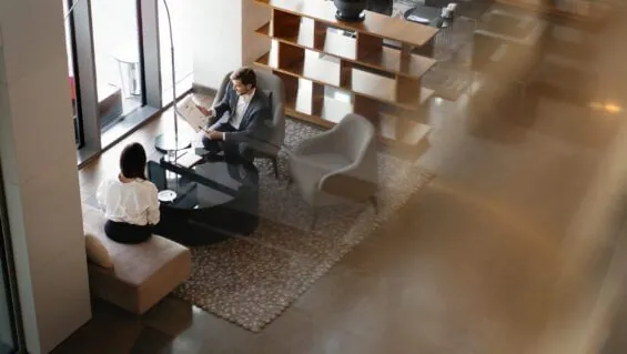 A top view of two business people having a conversation in a modern coworking space.