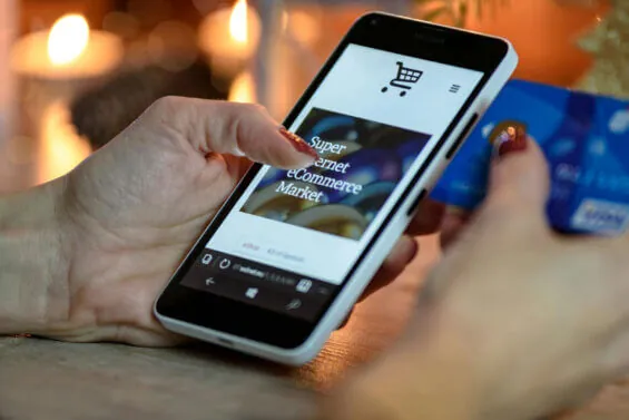 A woman uses her phone to browse an e-commerce shop.