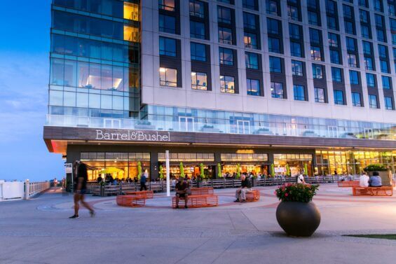 The courtyard in front of a mixed-use building with a restaurant on the first floor.